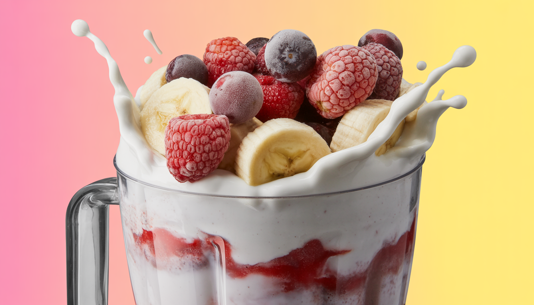 A blender filled with coconut milk, frozen berries, and bananas in the process of making a smoothie.