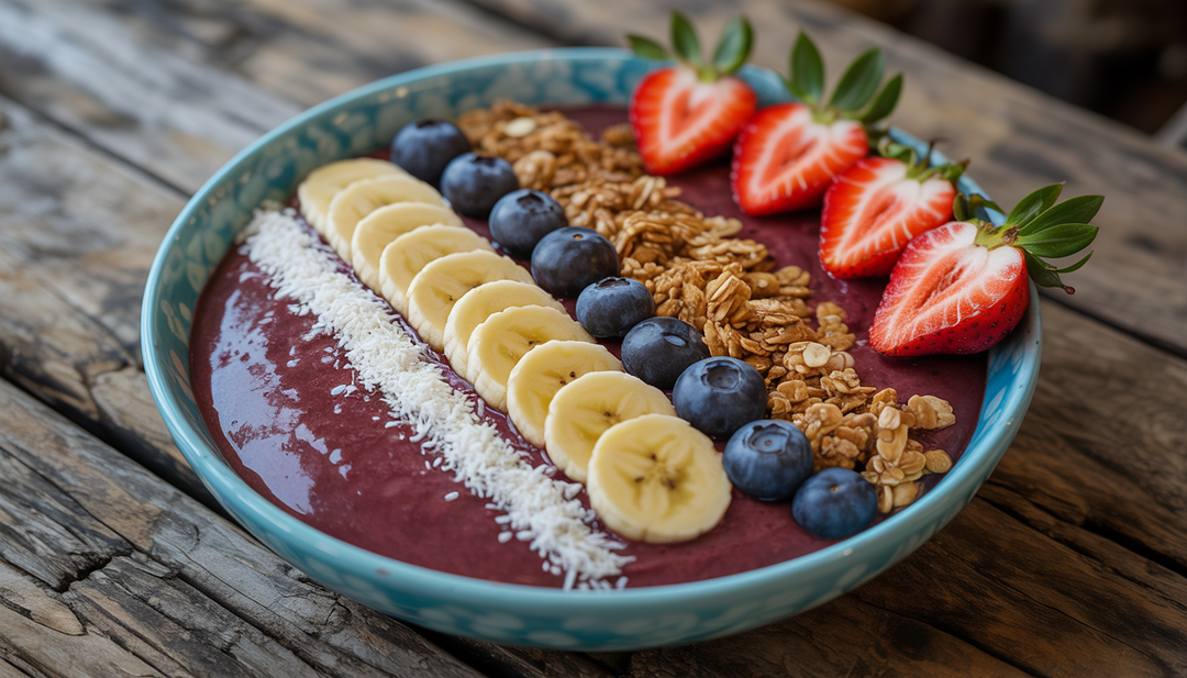 An acai bowl topped with fresh fruits, granola, and coconut flakes on a wooden table.