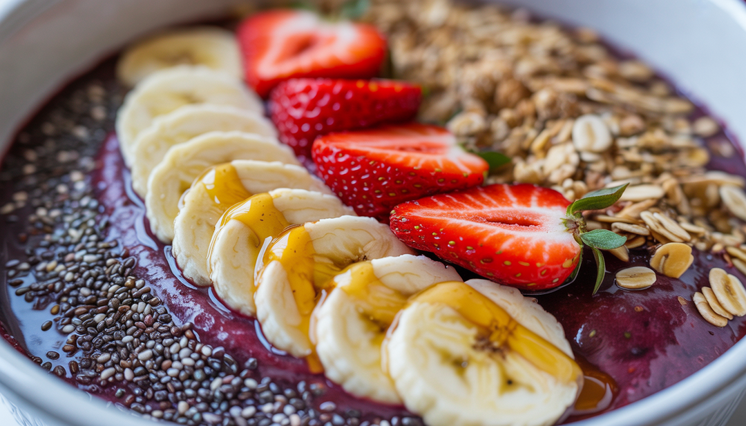 Close-up of an acai bowl with colorful toppings like bananas, strawberries, chia seeds, and granola.